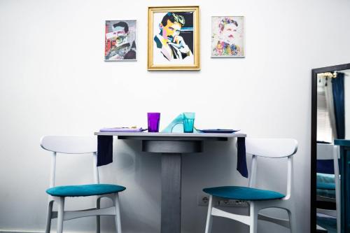 a table with two stools and a sink in a room at Apartment Tesla Wizard in Belgrade