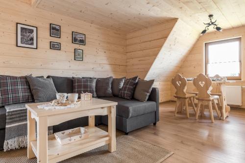 a living room with a couch and a table at Góralska Chata przy Dolinie Chochołowskiej - gorąca balia in Witów