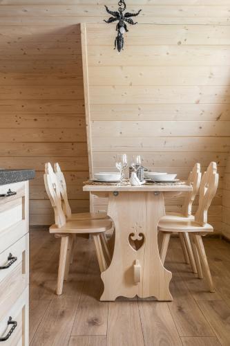 a dining room with a wooden table and chairs at Góralska Chata przy Dolinie Chochołowskiej - gorąca balia in Witów