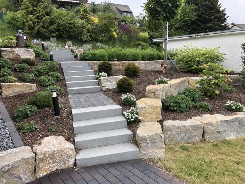a garden with stone steps and a rock wall at Fewo Auszeit zum Anspel in Medebach