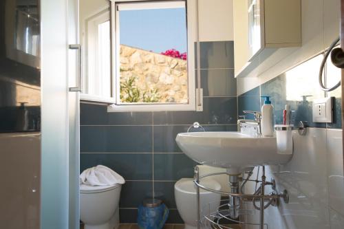a bathroom with a sink and a toilet and a window at Villino Fraginesi in Castellammare del Golfo