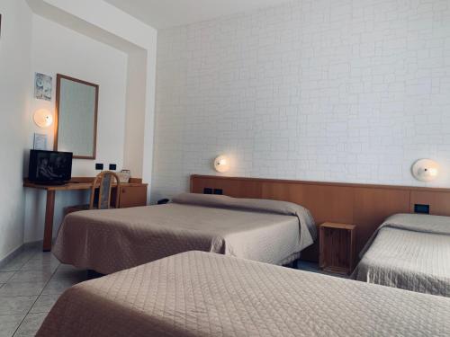 a hotel room with two beds and a mirror at Hotel San Giorgio in Albisola Superiore