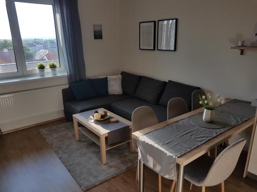 un salon avec un canapé et une table dans l'établissement KaVi Apartments #1, TOP sunset view, à Plzeň