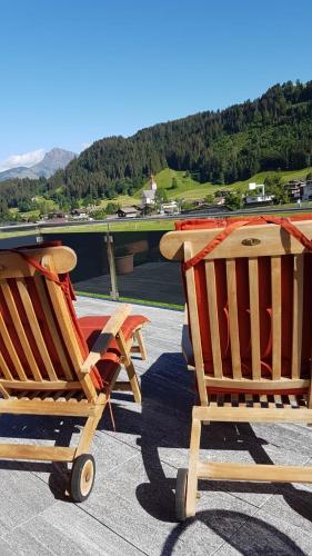 two rocking chairs sitting on top of a roof at Alpenchalet "DAHOAM" in Going