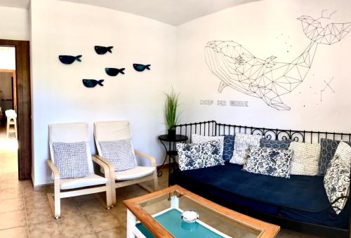 a bedroom with a bed and two chairs at La Chumbera in San José