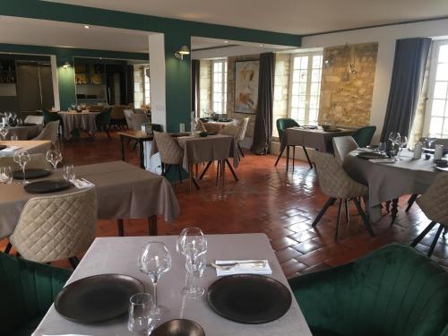 Le Gua的住宿－紅磨坊德沙隆洛基斯酒店，用餐室配有桌椅和酒杯