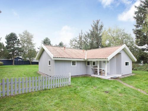 una casa blanca con una valla en un patio en 8 person holiday home in R dby en Kramnitse