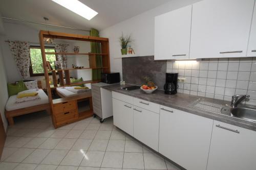 a kitchen with white cabinets and a sink at Wessely Appartements am Golfplatz in Innsbruck
