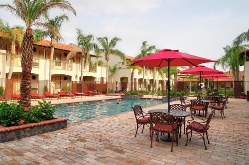 a patio with tables and umbrellas next to a pool at The Bungalows on Shary in McAllen