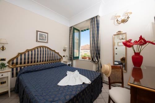a bedroom with a blue bed with white shoes on it at Amalfi Old Square room & apartments , 73 steps from the street in Amalfi