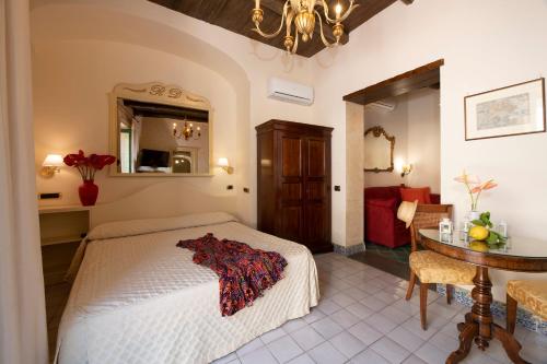 a bedroom with a bed and a table in a room at Amalfi Old Square room & apartments , 73 steps from the street in Amalfi