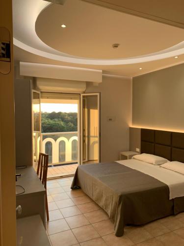 a bedroom with a bed and a desk and a window at Hotel Adria in Milano Marittima