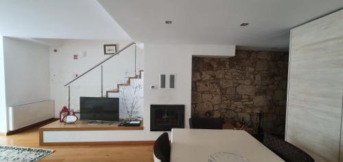 a living room with a television and a fireplace at Casas de Campo da Barroca in Tabosa