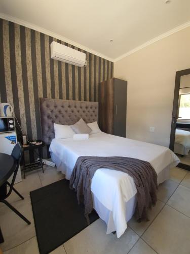 a bedroom with a large white bed in a room at Maraba Manor in Vryburg