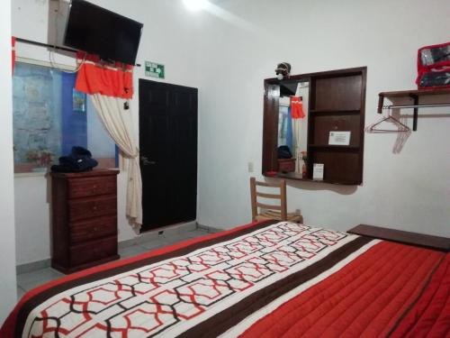 a bedroom with a bed and a dresser and a window at Kali Huasteca Posada in Ciudad Valles