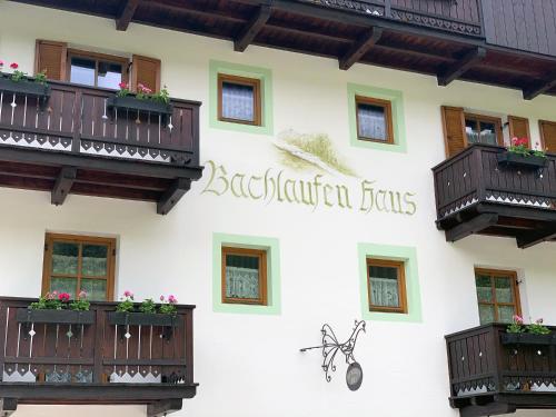 a building with balconies and a sign on it at Bachlaufen Haus in Sesto
