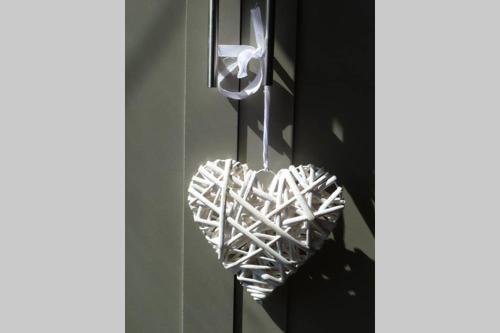 a white heart ornament hanging from a wall at Cosy and Peaceful Maisonette with Terrace, Kidderminster in Kidderminster