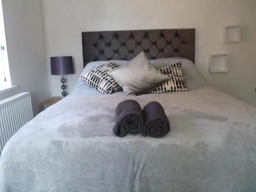 a bed with two towels and pillows on it at Cosy and Peaceful Maisonette with Terrace, Kidderminster in Kidderminster