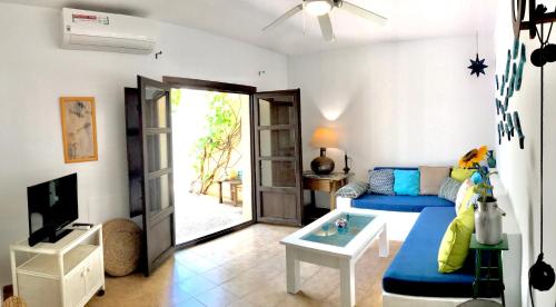 a living room with a blue couch and a tv at La Chumbera in San José