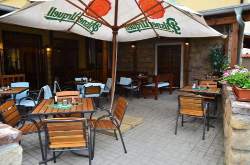 a patio with tables and chairs and an umbrella at Pension Wallis in Pilsen
