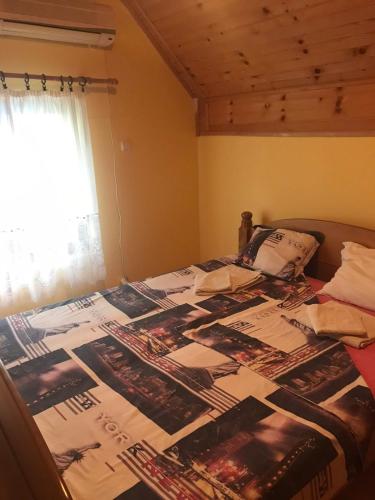 a bed with a bunch of pictures on it at Kod Dace in Banja Topilo