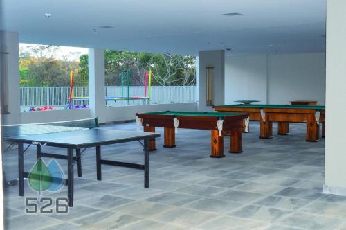 a room with three ping pong tables in it at Park Veredas - Apto 526 - Flat Service in Rio Quente