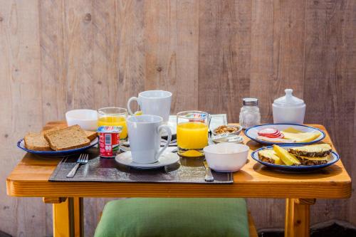 a wooden table with breakfast foods and drinks on it at Hotel Casa Algarrobo in San Pedro de Atacama