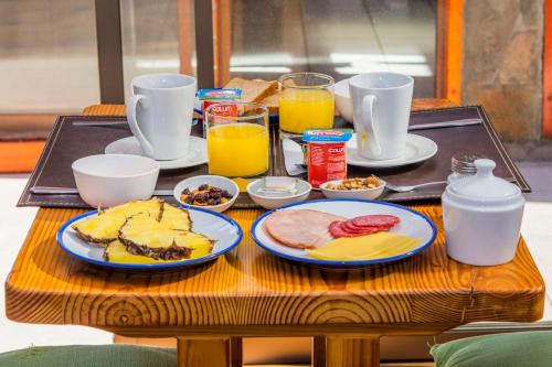 a table with breakfast foods and drinks on it at Hotel Casa Algarrobo in San Pedro de Atacama