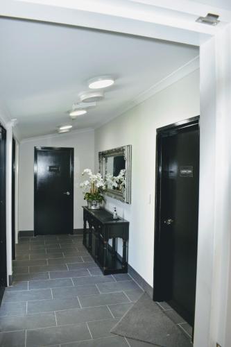a hallway with two black doors and a table at CocoBrew Boutique Apartments in Rockhampton