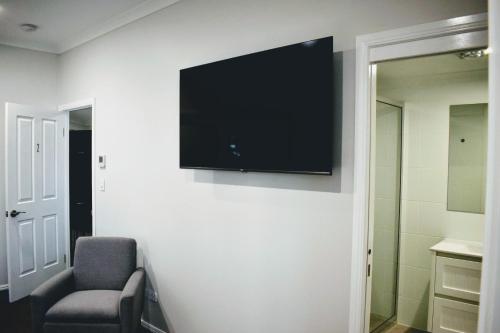 a flat screen tv on a wall in a room at CocoBrew Boutique Apartments in Rockhampton