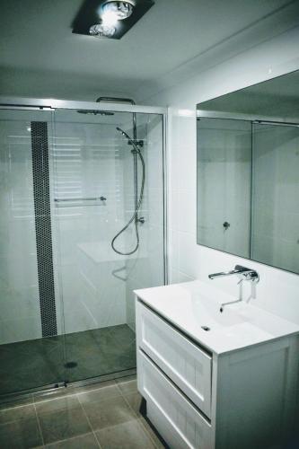 a bathroom with a shower and a sink and a mirror at CocoBrew Boutique Apartments in Rockhampton