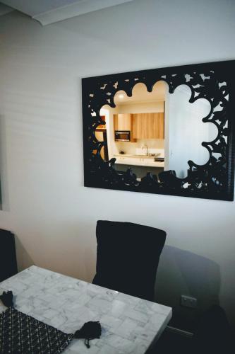 a bathroom with a table and a mirror on the wall at CocoBrew Boutique Apartments in Rockhampton