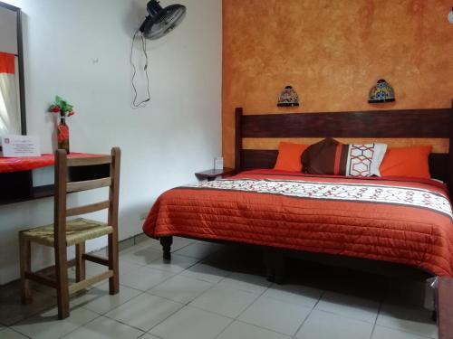 a bedroom with a bed and a table and a chair at Kali Huasteca Posada in Ciudad Valles