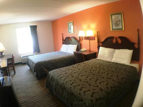 ein Hotelzimmer mit 2 Betten und einem Fenster in der Unterkunft President Inn & Suites in Gettysburg