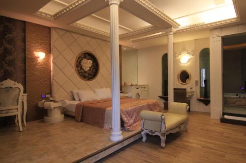 a large bedroom with a bed and a chair at Romantic Code Art Motel in Shanhua