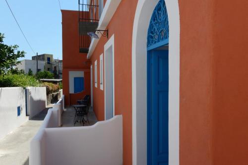 an orange and white building with a blue door at Hotel A Cannata in Santa Marina Salina