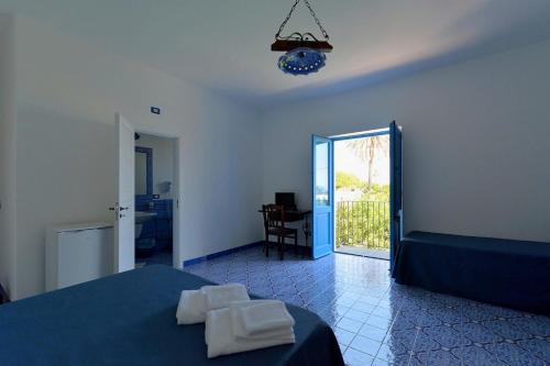 - une chambre avec un lit et une porte donnant sur une terrasse dans l'établissement Hotel A Cannata, à Santa Marina Salina