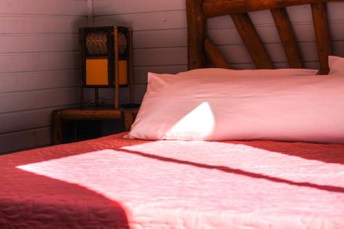 a bed with a red and white blanket on it at Pousada Cabanas Xokleng in Urubici