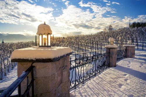 a gate in a vineyard covered in snow at Huebenburg in Appiano sulla Strada del Vino