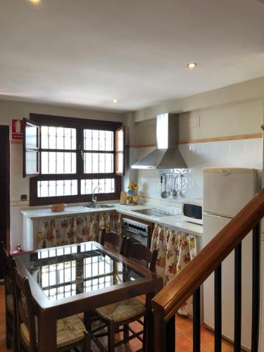 a kitchen with a table with chairs and a refrigerator at La casa de Tita Elvira 2 in Zafarraya