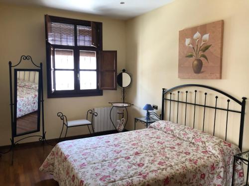 une chambre avec un lit et un miroir dans l'établissement La casa de Tita Elvira 6, à Zafarraya