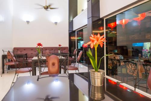 The Holidays Hill betong في بيتونغ: غرفة طعام مع طاولات وكراسي و مزهرية بها زهور