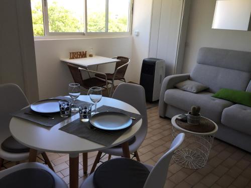 un salon avec une table, des chaises et un canapé dans l'établissement Studio , proche plages,classé 3 étoiles, à Balaruc-les-Bains