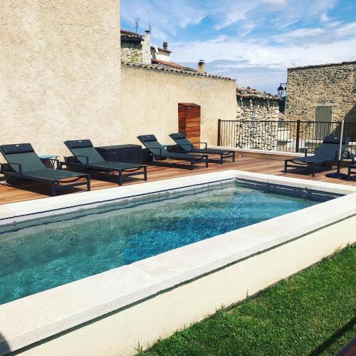 - une piscine avec chaises longues sur la terrasse dans l'établissement Ferme La Clavière, Maison de vacances Lou Mas, à Mane