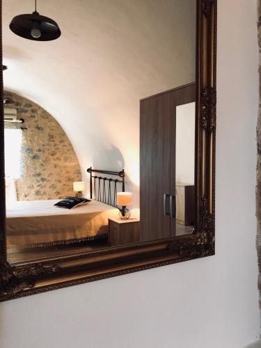 a mirror on a wall with a bed in a room at Kamares Stone House 1 in Gerolimenas