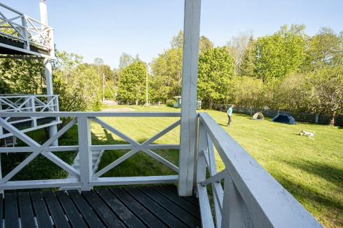 a person walking a dog on a porch with a field at Guest House Rannaliiv in Võsu