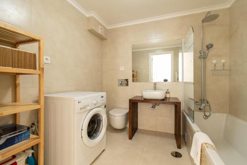 a bathroom with a washing machine and a sink at Casa Carolina in Vila Real de Santo António