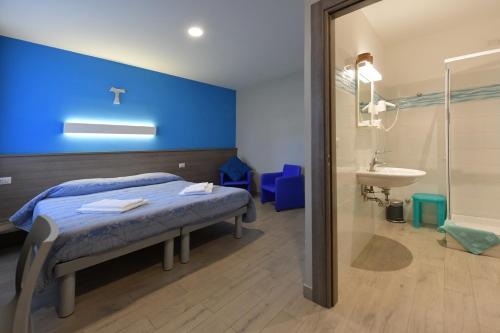 una camera ospedaliera con un letto e un lavandino di Serafico Guesthouse a Roma