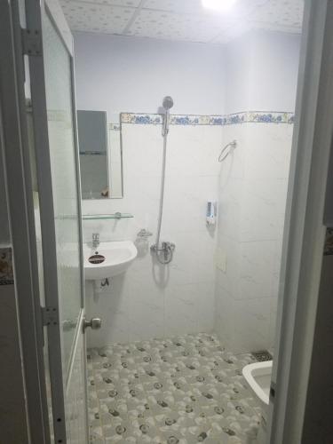 a white bathroom with a sink and a shower at MyDungmotel in Danang