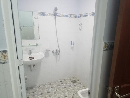 a white bathroom with a sink and a shower at MyDungmotel in Da Nang